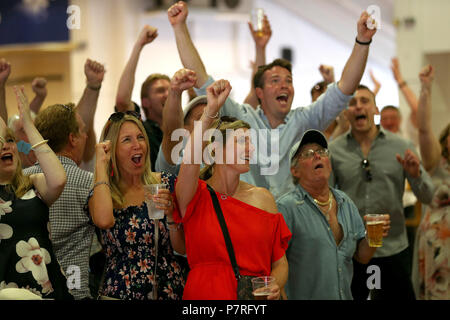 Racegoers feiern Englands zweite Ziel gegen Schweden in den FIFA-WM-Viertelfinale während Coral Eclipse Tag in Sandown Park Racecourse, Esher. Stockfoto