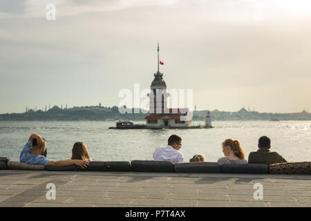 Menschen sitzen und die Aussicht genießen mit Maiden's Tower oder Kız Kulesi im Hintergrund, Istanbul, Türkei Stockfoto