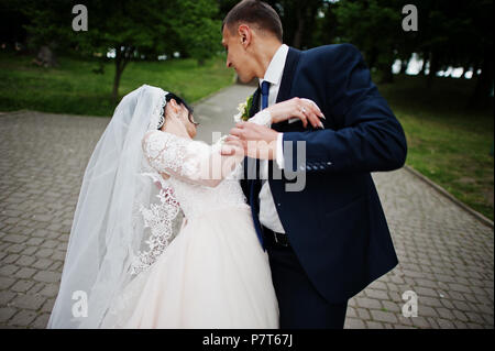 Romantische neu verheiratete Paare tanzen im Park am Tag ihrer Hochzeit. Stockfoto