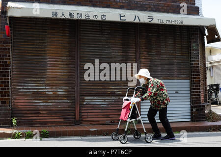 Eine ältere Frau entlang einer Straße in Osaka, Japan. Stockfoto