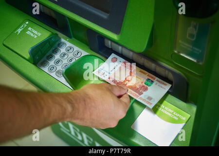 Syzran, Russland - 20. Juni 2018: Finanzen, Geld, Bank und Personen Konzept - Nahaufnahme einer Hand, Erhalt von Geldautomaten der Sberbank Stockfoto