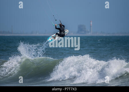 Kite Surfer Fänge Luft, als er sich auf den Weg, um die Wellen wirkt durch den shorebreak am Punkt der Surfer in Ventura am 6. Juli 2018. Stockfoto