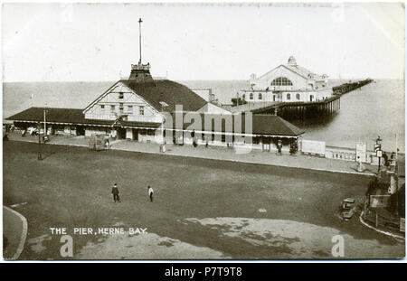 Postkarte vom 1810-1828 Übersicht Die dritte Herne Bay Pier, die 1899 erbaut wurde. Grand Pier Pavillon, hier gezeigt, errichtet 1910, und der Pier Eingang noch nicht abgebrannt (1928). Es gibt keinen Stempel, aber die Kleider von Frauen sind noch lang und Edwardianische Kragen sind verschlissen, und auf der Rückseite heißt es "Britische Herstellung gesamte", vielleicht, weil früher Karten in Dresden gedruckt wurden. Daher ist es möglicherweise um 1914 datiert. Zwischen 1910 und 1928 10 3 Herne Bay Pier 1910-1928 027 Stockfoto