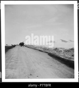 Persien, Hamadan: Landstraße (Lokalisierung unsicher); Landstraße mit Pferdewagen in der Ferne, schneebedeckte Felder und im Hintergrund Berge. Von 1933 bis 1934 77 CH-NB-Persien, Hamadan - Landstraße (Lokalisierung unsicher) - Annemarie Schwarzenbach - SLA-Schwarzenbach-A -5-04-002 Stockfoto