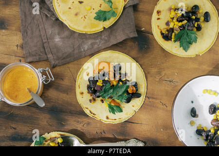 Ansicht von oben Lecker und gesund Essen Konzept. Vegetarische gesunde Maistortillas mit Gemüse auf hölzernen Tisch Stockfoto