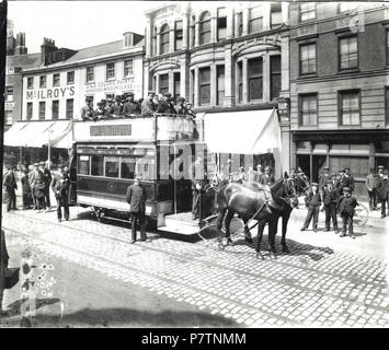 Englisch: Lesen Straßenbahn Unternehmen. Pferd - Tram Nr. 4 in der Broad Street, C. 1900, Richtung Osten auf der 'Kaserne - Friedhof - Palmer Park' Route. Der Fahrer, Dirigent und Inspektor posieren für die Kamera. Die Limousine ist fast leer, aber das Oberdeck ist drängten, und es gibt mehrere Zuschauer im Bild. Erkennbar Geschäfte im Hintergrund: Nr. 50 (William McIlroy, Boot und Shoe Warehouse); Nr. 49 (William Archer Öle, Farben, Farben und Lacke); Nr. 47 amd 48 (A. H. in der Stier, Herren- und Ausstatter Boys'); Nr. 46 (Dowsett Brüder, Brauereien). 1900-1909: Fotografie von Walton Adams. Stockfoto