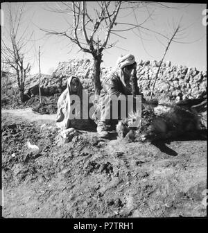 Afghanistan, Ghazni (ghaznah) Lehrwerk:; ein Mann und Art mit einem am Boden liegenden Schaf, im Hintergrund Lehmmauern. Von 1939 bis 1940 64 CH-NB-Afghanistan, Ghazni (ghaznah) - Menschen - Annemarie Schwarzenbach - SLA-Schwarzenbach-A -5-21-163 Stockfoto