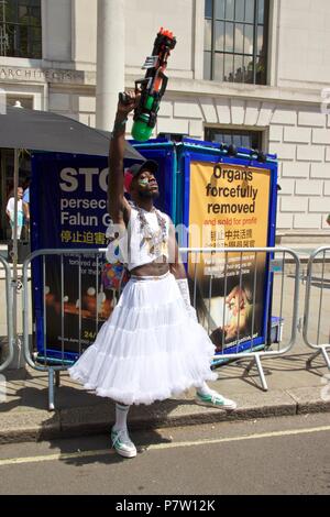 London, Großbritannien. 7. Juli 2018. Ein Mann in einem weißen Rock mit einer Wasserpistole in der Luft im Pride Parade in London 2018, der heute mehr als 1 Millionen verbinden die Teilnahme an der März LGBT + zu feiern. Credit: Dimple Patel/Alamy leben Nachrichten Stockfoto