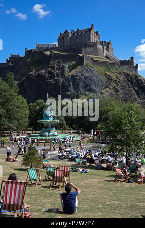 Edinburgh, Schottland, Großbritannien. Vom 8. Juli 2018. Ross Brunnen, West Princes Street Schalter Gärten am Tag, Massen von Familien und Touristen in der Sonne zu sehen, die zirkusvorstellungen und Edinburgh's School Pipe Band und Baden im Brunnen Wasser, das im Jahr 2010 geschaltet wurde. Stockfoto
