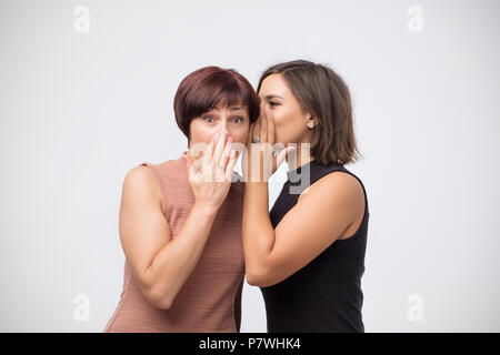 Frauen Mutter und Tochter klatschen und sagen ein Geheimnis Stockfoto