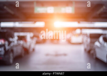 Blurry der Pkw-parkplätze am Kaufhaus mit orange Sonne Licht. Abstrakte und Transportkonzept. Stockfoto