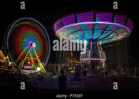 Bunte, Bewegungs Unschärfen - Ferris​ Rad und Schwingen reitet und geisterhaften Menschen bei der Calgary Stampede Midway in Calgary, Alberta, Kanada. Stockfoto