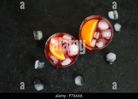 Negroni Cocktail mit Orangen und Eis. Hausgemachte klassische Negroni Cocktail und Zutaten auf schwarzem Hintergrund, kopieren. Stockfoto