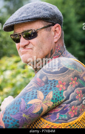 Im mittleren Alter Mann mit japanischen Blumenmuster Tattoos, England, Großbritannien Stockfoto