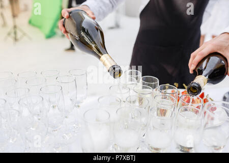 Barkeeper Champagner in Gläser gießen. Bankett im Restaurant Stockfoto