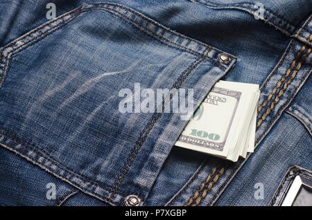 Banknoten eines hundert Dollar peep aus der Tasche der Jeans Hose. Geld in der Tasche, Geld sparen, Spesen. Das letzte Geld, das Econ Stockfoto