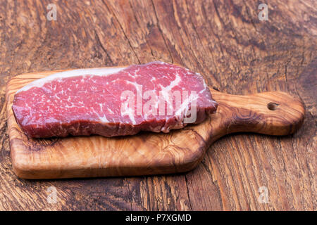 Rohen Steak auf Olivenholz Stockfoto