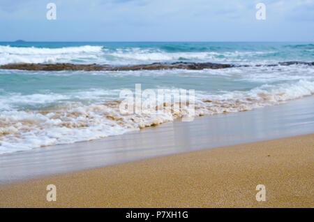 Sandstrand mit einem unscharfen Hintergrund Wellen Stockfoto