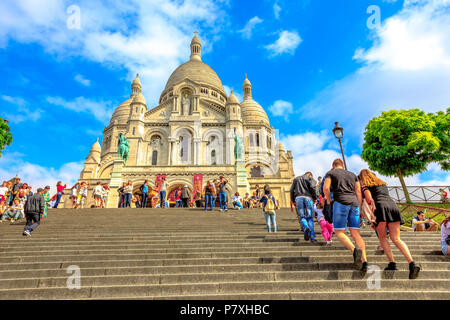 Paris, Frankreich, 3. Juli 2017: Touristen klettert die Treppe zur Basilika von Sacré Coeur de Montmartre in Paris an einem sonnigen Tag mit blauen Himmel. Herz-jesu-Kirche ist eine beliebte touristische Sehenswürdigkeit. Stockfoto