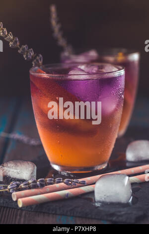 Pfirsich Aperol Spritz Schichten mit Pfirsich und Lavendel Wasser auf Holzschreibtisch. Stockfoto