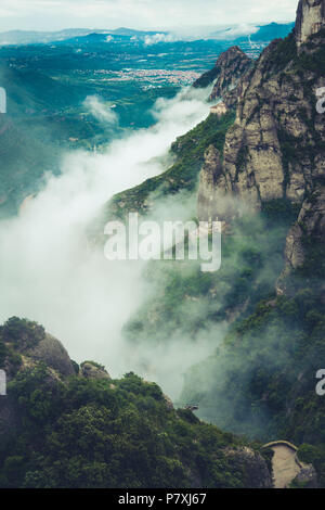 Berge in der Nähe von Kloster Montserrat in Spanien. Wolken und Nebel. Bäume auf Klippen. Sommer Urlaub in den Bergen. Stockfoto