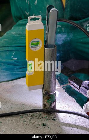 Schweißnähte an einem Geländer bei der Renovierung des Daches in den Abend in Italien Stockfoto