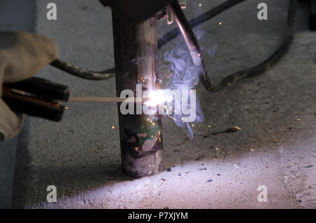 Schweißnähte an einem Geländer bei der Renovierung des Daches in den Abend in Italien Stockfoto