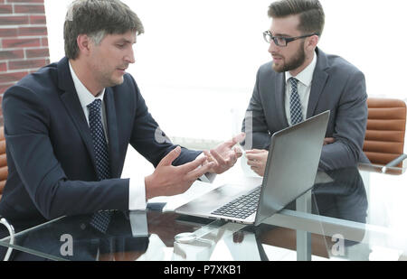 Zwei Geschäftsleute über Aufgaben im Büro sitzen. Stockfoto