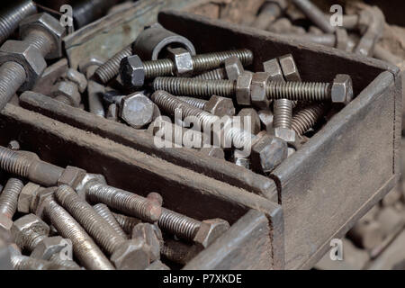 Blick auf schmutzige Muttern und Schrauben in der Fabrik. Stockfoto