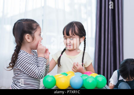 Zwei kleine Mädchen und junge spielt kleines Spielzeug Bälle im Haus zusammen. Bildung und Glück lifestyle Konzept. Lustig lernen und Kinder Entwicklung Stockfoto