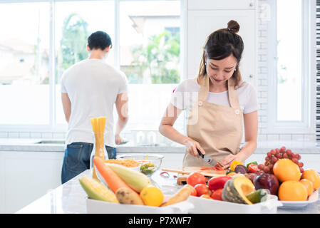 Asiatische Liebhaber oder paar Kochen und Schneiden von Gemüse in der Küche Zimmer. Urlaub und Hochzeitsreise Konzept. Valentinstag und Hochzeit Thema Stockfoto