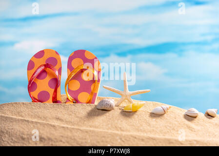 Sandalen und Muscheln und Fisch am Strand mit blauer Himmel. Sommer und Travel Concept. Stockfoto