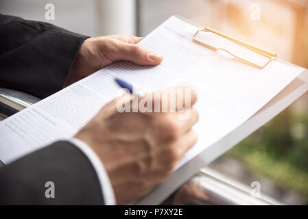 Geschäftsmann am Schild Papier unterzeichnet, geschäftliche Vereinbarung Konzept, selektiver Fokus auf der linken heand Stockfoto