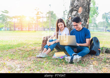 Zwei Asiatische junge Hochschule Leute über Hausaufgaben und eine abschließende Untersuchung der Diskussion für das Testen mit Laptop. Bildung und Freundschaft Konzept. Glück ein Stockfoto