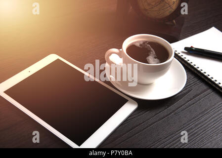 Tablet und schwarzen Kaffee auf Holztisch mit digitalen Erde Weltkarte und orange Licht und Linie dot, Notizbuch und Stift, Technologie, Konzept, Trinken und Stockfoto