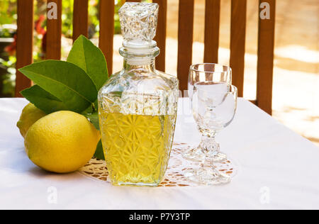 Lemoncello und Zitronen auf einem Sommer Tabelle einstellen Stockfoto