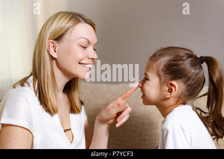 Glücklich liebende Familie. Schöne Mutter tröstet seine junge frustrierte Tochter. Stockfoto