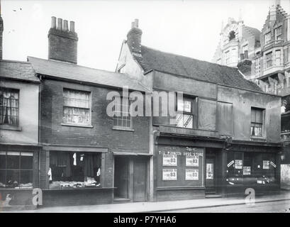 Englisch: Oxford Road, Reading. Nordseite, C. 1902. Teil Nr. 42 (Henry James Abery, Second Hand Kleidung Händler); Nr. 40; Nr. 38 (früher Pionier Drug Store von Kreuz und Unternehmen, die mit der zahnärztlichen Chirurgie oben, jetzt leer); Nr. 36 (Francis John lesen, Schneider, jetzt leer); der Ecke Cheapside (ehemals Weingut genannt), mit der neuen Kaufhaus der William McIlroy Ltd. Kurz vor der Fertigstellung an Nr. 34. 1900-1909: Fotografie von Walton Adams. Teil dieses Foto wurde verwendet, Postkarte, Dynix 1221788. 1902 298 Oxford Road, Reading, C. 1902 (2) Stockfoto