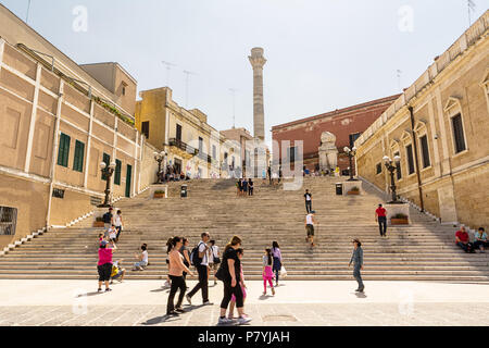 Brindisi, Italien - 30. April 2018: Terminal Spalten der antiken Via Appia in Rom beginnt und endet in Brindisi (Italien) und Touristen, die in Stockfoto