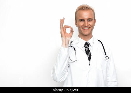 Doktor mit Stethoskop zeigen Sie OK oder sämtliche rechte Zeichen mit seiner Hand auf den weißen Hintergrund. Ärzte und medizinisches Konzept. Krankenhaus Thema Stockfoto