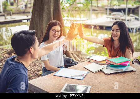 Asiatische Menschen hoch fünf tun für den Start Neues Projekt. Geschäft der Jugend Konzept. Erfolgreiche und Teamarbeit der jugendlich Thema. Bücher und Tablet und Vortrag Stockfoto
