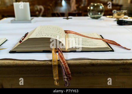 Beten sie auf dem Altar in einer Kirche vor einer Hochzeit auf der Bibel ausgerichtet Stockfoto