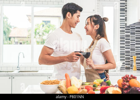 Asiatische Liebhaber oder Paare, Wein trinken und in der Küche Zimmer zu Hause. Liebe und Glück Konzept süßen Flitterwochen und Valentinstag Thema Stockfoto
