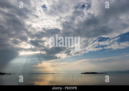 Spektakuläre Aussicht auf den See, mit den Wolken, der Himmel und die Sonnenstrahlen auf dem Wasser widerspiegeln Stockfoto