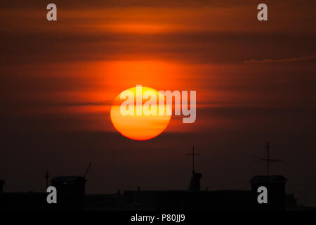 Riesige gelbe Sonne über der Stadt Stockfoto