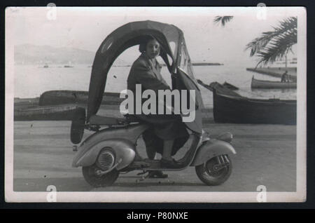 . Italiano: Piaggio, Vespa con Accessori, 1948. Italiano: una donna alla Guida di una Vespa arricchita di Accessori, il parabrezza e il parapioggia, Pro renderla piu' confortevole e Pratica, 1948. Questo veicolo e 'considerato Economico e maneggevole Ed adatto a tutti coloro che vogliono muoversi rapidamente. (Wie Pescara, Archivio privato Corradino D'Ascanio, b. 2, verwischt. 34, n. 2). 1948 310 Piaggio, Vespa con Accessori, 1948 - San dl SAN IMG -00003403 Stockfoto