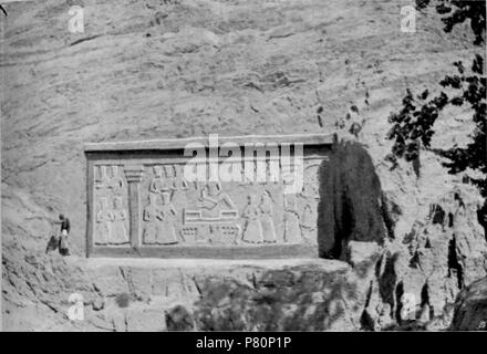 Englisch: Rock Skulptur in der Nähe von Shah-Abdul-Azim. Von Arnold Henry Savage Landor, 1901 fotografiert, wahrscheinlich im Oktober. Ab Seite 244 der über begehrte landet. Landor's Beschreibung: "Rechts von der Straße, ein wenig Abstand vor der Moschee, ein sehr ruhiges, großes, Relief modellierte wurde auf dem Gesicht eines riesigen Felsen hat und kopfüber in einen Teich mit Wasser zu seinen Füßen nieder. Männer waren Baden hier in Langen roten oder blauen Schubladen, und Hunderte von Eseln wurden Förder verschleierte Frauen an dieser Stelle. Ein riesiger Baum wirft ihren Schatten über den Pool von Wasser am Vormittag. Es ist interessant Stockfoto