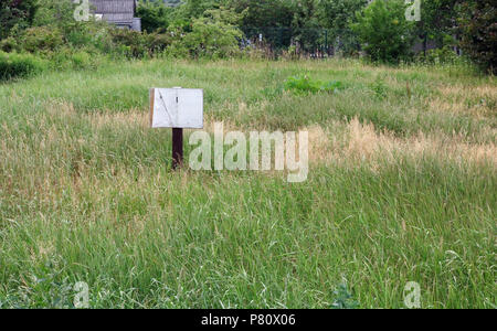 Banner - Zum Verkauf - im dichten Gras auf einem verlassenen Dorf Farm entfernt Stockfoto