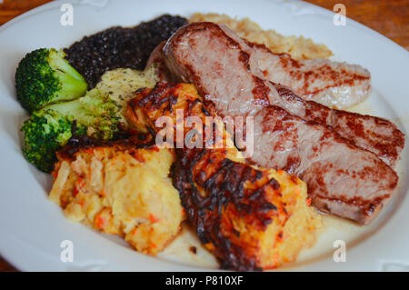 Einfache deutsche Gericht zum Mittagessen aus Schweinefleisch steak Slices, Sauerkraut, schorles und Beluga Salat mit Linsen Stockfoto