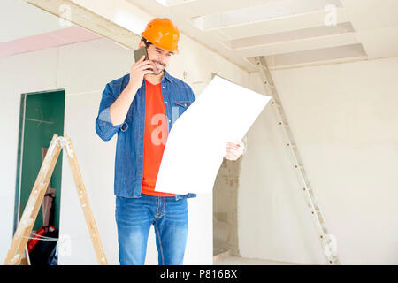 Porträt der jungen Handwerker Hand blueprint und Anruf beim Stehen an der Baustelle. Stockfoto